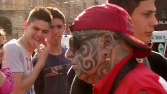 Уличная фотография Турина март 2012 на площади и рынке Бенгази Уличный артист выступает на площади в центре Турина, вокруг него зрители, рядом видны городские здания и люди, идущие по делам, весенний день марта 2012 года.