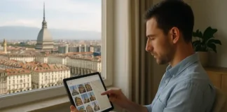 Цифровой архив архитектуры Турина: как город сохраняет память о своих зданиях Вид на архитектуру Турина и человека, просматривающего цифровой архив зданий на планшете На переднем плане человек сидит за столом у окна с видом на центр Турина, на столе открыт планшет с картой города и превью исторических зданий. В окне видны крыши Турина и силуэт Моле Антонеллиана. Мягкий дневной свет, современный, но уютный интерьер
