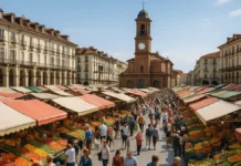 Центральный рынок Турина Porta Palazzo — как добраться, что купить и когда идти Центральный рынок Турина Porta Palazzo - прилавки с фруктами и людьми Широкий вид на центральный рынок Porta Palazzo в Турине с цветными рядами фруктов и овощей, людьми между прилавками и историческими домами на фоне.