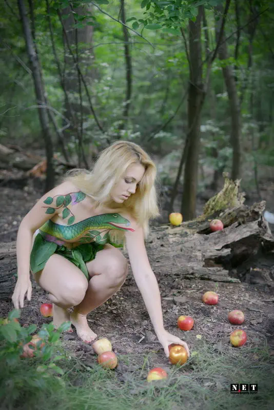 Модель собирает яблоки в лесу Бодипейнтинг в Италии