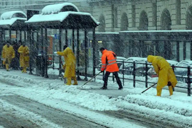 Рабочие чистят снег на остановке площади Кастелло