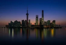 Самые высокие небоскрёбы Италии и мира, топ-10 и архитектурные рекорды Самые высокие небоскрёбы мира и Италии по CTBUH Ночной панорамный вид на современные небоскрёбы с подсветкой, отражение в воде, акцент на высотные башни лидеров рейтинга.