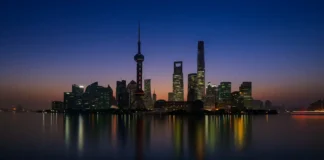 Самые высокие небоскрёбы Италии и мира, топ-10 и архитектурные рекорды Самые высокие небоскрёбы мира и Италии по CTBUH Ночной панорамный вид на современные небоскрёбы с подсветкой, отражение в воде, акцент на высотные башни лидеров рейтинга.