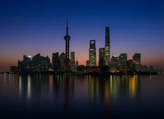 Самые высокие небоскрёбы Италии и мира, топ-10 и архитектурные рекорды Самые высокие небоскрёбы мира и Италии по CTBUH Ночной панорамный вид на современные небоскрёбы с подсветкой, отражение в воде, акцент на высотные башни лидеров рейтинга.