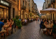 Новые гастрономические открытия в Турине летом 2025: пять заведений с качественной кухней и разумными ценами Новые рестораны в Турине летом 2025 Летняя улица Турина с людьми, сидящими на открытых верандах новых ресторанов, среди стильного городского дизайна и зелени.