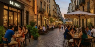 Новые гастрономические открытия в Турине летом 2025: пять заведений с качественной кухней и разумными ценами Новые рестораны в Турине летом 2025 Летняя улица Турина с людьми, сидящими на открытых верандах новых ресторанов, среди стильного городского дизайна и зелени.