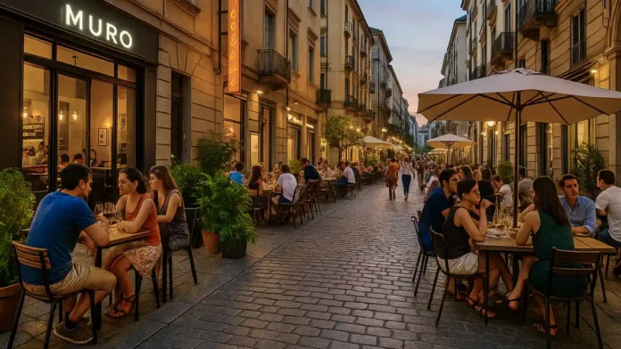 Новые рестораны в Турине летом 2025 Летняя улица Турина с людьми, сидящими на открытых верандах новых ресторанов, среди стильного городского дизайна и зелени.