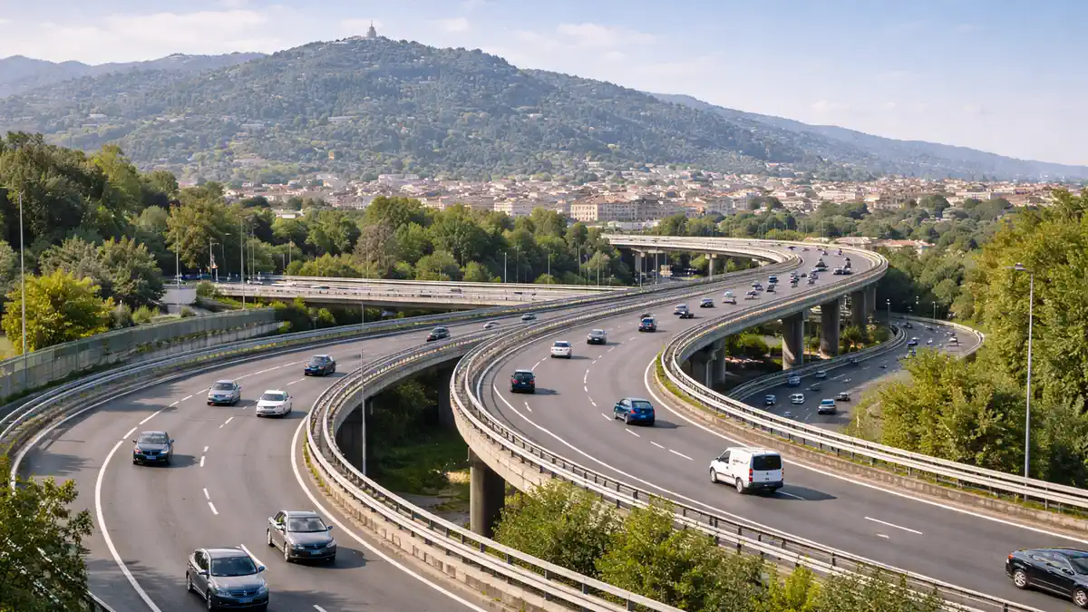 Кольцевая автострада Турина A55: схема объездной и восточный проект Сцена Турина и объездной: современная развязка на закате дня без текста и брендов, вид на холмы вдали, лёгкий трафик, атмосфера городской логистики.