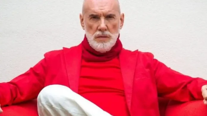 diego-dalla-palma-last-makeup Диего Далла Пальма сидит у окна с бокалом вина, задумчивый взгляд, мягкий свет Элегантный пожилой итальянец с ухоженным лицом за столом у окна, бокал вина, атмосфера покоя и прощания.