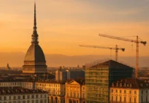 Новые отели в Турине: кто строит люкс и почему ввод переносится до 2028 Новые люкс-отели в Турине карта проектов и сроки 2025–2028 Панорама центра Турина с силуэтом Mole Antonelliana и строительными кранами визуальный образ обновления гостиничного рынка