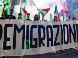 Плакат Remigrazione на площади в Тренто акция Comitato Remigrazione e Riconquista Широкоформатная фотография ночного митинга Comitato Remigrazione e Riconquista в piazza Cantore, Тренто; в кадре баннеры, участники и уличные огни