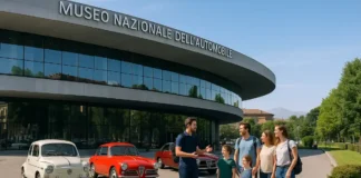 Национальный автомобильный музей в Турине: что посмотреть, как добраться и стоит ли идти с детьми Национальный автомобильный музей MAUTO в Турине – вход и классические автомобили вид Национального автомобильного музея MAUTO в Турине: здание у реки По, перед входом несколько классических итальянских автомобилей, люди с детьми заходят в музей, солнечный день, современная, но уютная атмосфера.