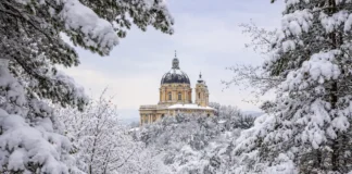 Рождественские снегопады в Италии: рекорды Пьемонта, открытые трассы и риск лавин Базилика ди Суперга после рекордного снегопада в Альпах Пьемонта после рождественского снегопада: заснеженные ели, голубое зимнее небо, чистый свежий снег.