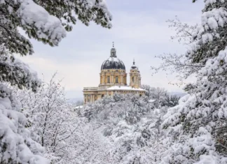 Рождественские снегопады в Италии: рекорды Пьемонта, открытые трассы и риск лавин Базилика ди Суперга после рекордного снегопада в Альпах Пьемонта после рождественского снегопада: заснеженные ели, голубое зимнее небо, чистый свежий снег.