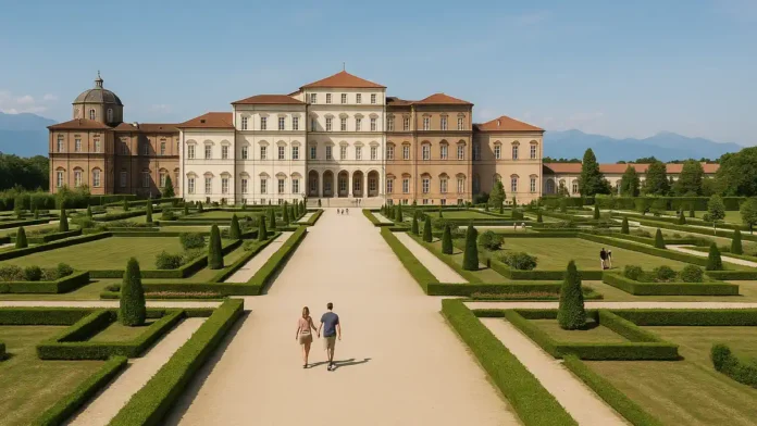 Королевский дворец Венария Реале под Турином и сады перед фасадом в солнечный день Широкий вид на фасад Королевского дворца Венария Реале под Турином с зелёными садами, дорожками и посетителями на переднем плане в ясный день.
