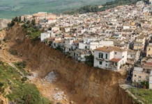 Оползень в Нискеми (Сицилия) расширяется: эвакуации, зона риска растёт, дома под угрозой Оползень в Нискеми, Сицилия: эвакуация жителей и зона риска после непогоды итальянские спасатели и жители у ограждений «красной зоны», служебные машины на фоне, пасмурный день, ощущение организованной эвакуации и контроля безопасности